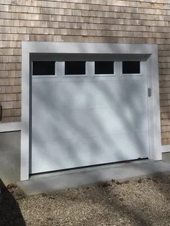 Modern insulated garage door with glazing on a Cape Cod home