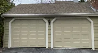 Insulated almond raised-panel double garage door on a Cape Cod home